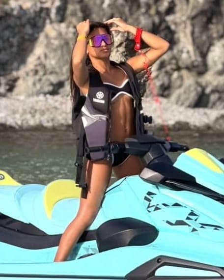 Clienta de Yuyu Showroom en moto de agua con el Bikini Leo negro de ribete blanco, traje de baño hecho en Caracas